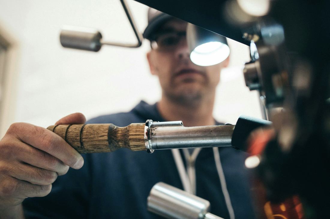Skilled tradesperson shaping a tool handle in the workshop